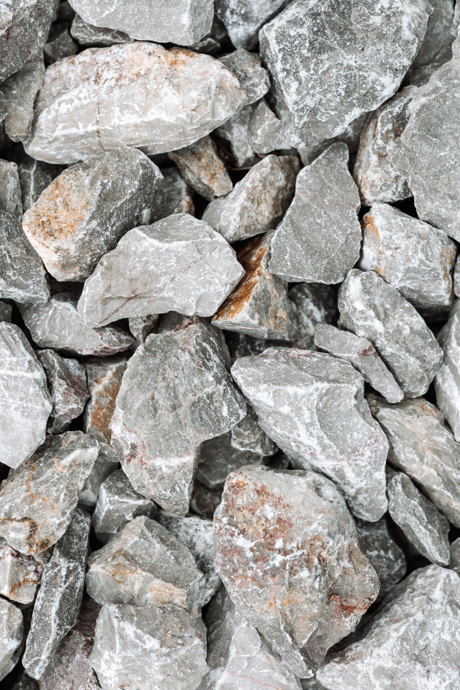 Close-up of crushed gray gravel-like stone particles, similar in texture to lava rock or pumice